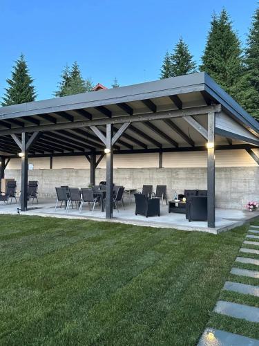a pavilion with tables and chairs in a yard at Monteluce Aframe in Mărişel