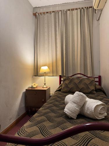 a bedroom with a bed with towels on it at Nuevo Hotel Pacifico in Mendoza