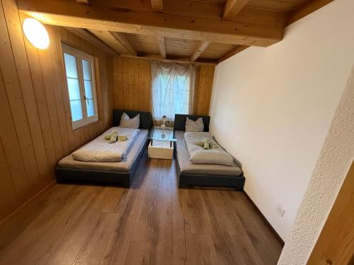 a room with two beds and a table in it at Appartment Happy Life - Wimmis - near Spiez-Thun- Interlaken in Arni Alp
