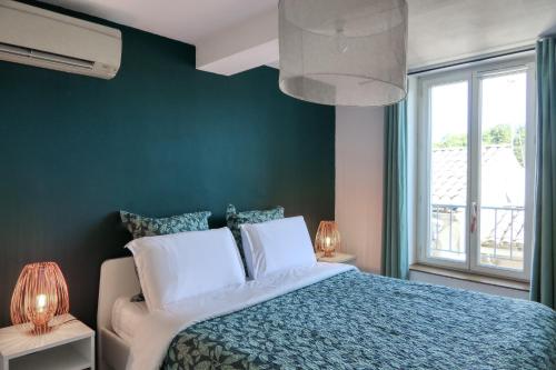 - une chambre avec des murs verts et un lit avec des oreillers blancs dans l'établissement Oasis de 42 m2 I Cosy I Cœur de ville I Lit 160x200, à Vaison-la-Romaine