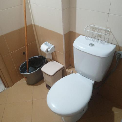a bathroom with a white toilet and a trash can at Saranda Kodra Underground Flat in Polisi i Vogël