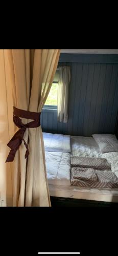 a bed with a curtain in a bedroom at The Yellow House in Bamble