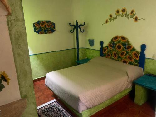 a bedroom with a bed and a cross on the wall at Hotel Quinta Bella in Tula de Allende