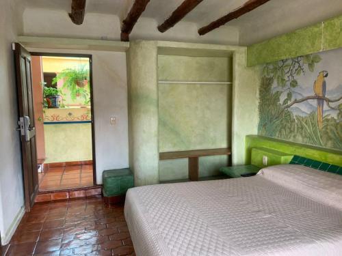 a bedroom with a bed and a painting on the wall at Hotel Quinta Bella in Tula de Allende