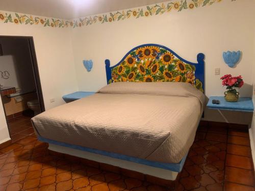 a bed with a blue headboard in a bedroom at Hotel Quinta Bella in Tula de Allende
