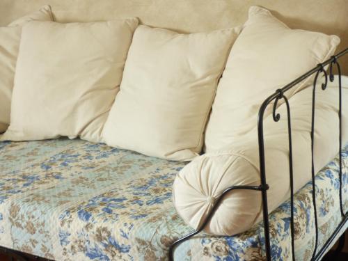 a bed with white pillows and a metal frame at Le CLOS D'ETRETAT in Les Loges