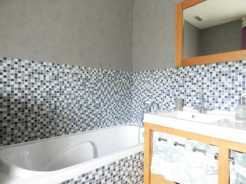 a bathroom with a white tub and a sink at Le CLOS D'ETRETAT in Les Loges
