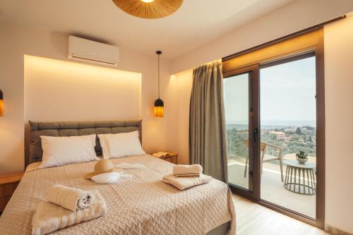 a bedroom with a bed and a large window at DK Luxury Villas in Sivota