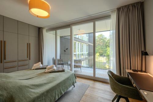 a bedroom with a large bed and a balcony at Marina Apartment am See mit Pool und Sauna in Bad Saarow