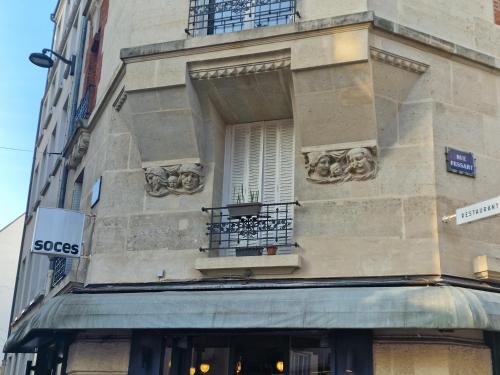 - un bâtiment avec une fenêtre et un balcon dans l'établissement Un magnifique appartement a Paris Jourdain, à Paris