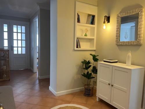 a room with a white cabinet and a mirror at Garden Beach Apartament in Boiro