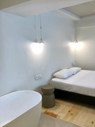 a bedroom with a bed and a bathtub and a toilet at Old Town Boutique Suites in Lefkada Town