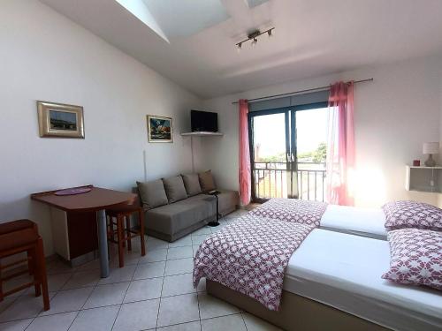 une chambre avec un lit, un canapé et une fenêtre dans l'établissement SeaView Studio, à Umag