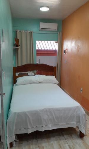 a bedroom with a white bed in a room with a window at Meu refúgio in Belém