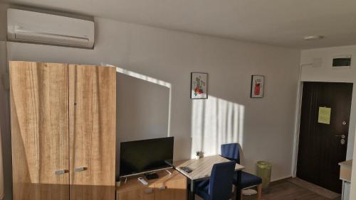 a room with a desk with a television and a cabinet at Banjica 202 in Voždovac