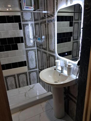 a bathroom with a sink and a mirror and a tub at Green House მწვანე სახლი in Sighnaghi