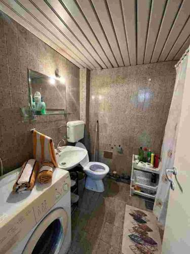 a bathroom with a washing machine and a toilet at Sivas Bar in Bar