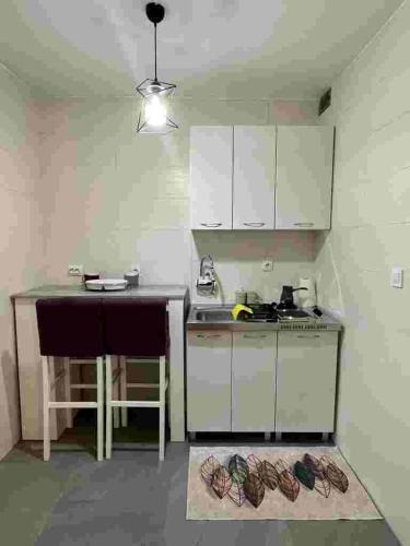 a small kitchen with white cabinets and a table at Sivas Bar in Bar