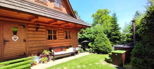 a log cabin with a bench in the yard at Liptovská Drevenica in Liptovský Mikuláš