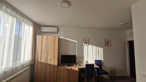 a room with a desk with a computer and a window at Banjica 202 in Voždovac