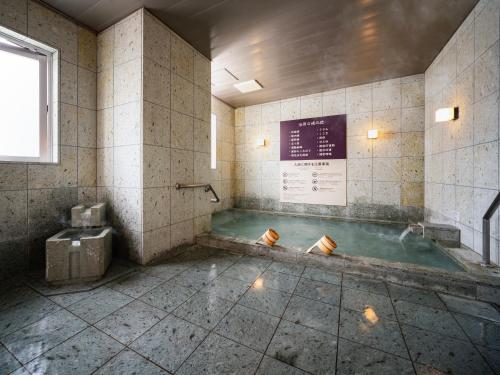 a bathroom with a pool of water in the floor at Super Hotel Kyoto Shijokawaramachi in Kyoto