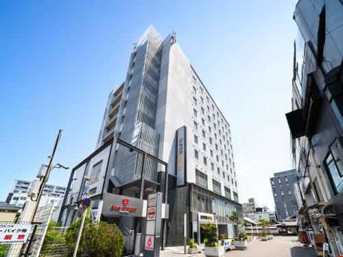 a tall building on a city street at Super Hotel Kyoto Shijokawaramachi in Kyoto