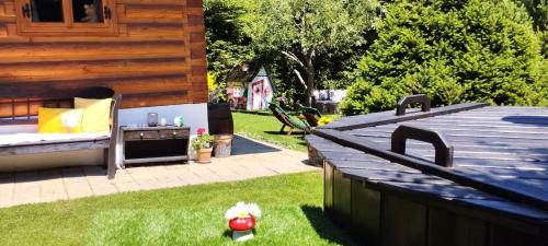 a backyard with a wooden deck and a grill at Liptovská Drevenica in Liptovský Mikuláš
