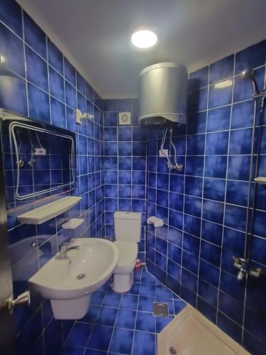 a blue tiled bathroom with a sink and a toilet at Taha Yahia Porto Matrouh For Family Only in Marsa Matruh