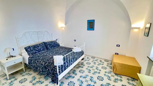 a bedroom with a bed with a blue and white comforter at Relais Amalfi Coast in Conca dei Marini
