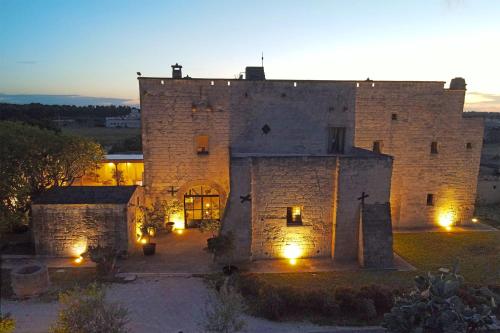 an old castle with lights in front of it at Masseria La Millenaria in San Foca