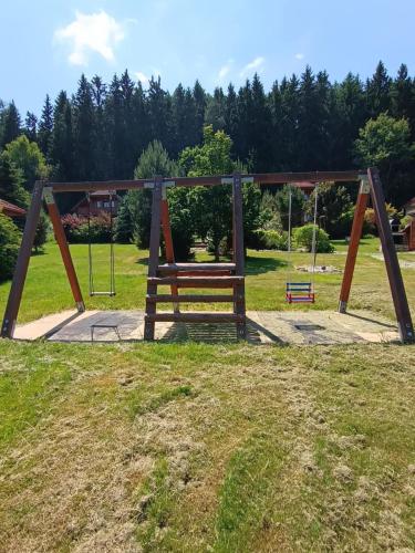a park with a bench and a swing at Chata Jindřiška in Borušov