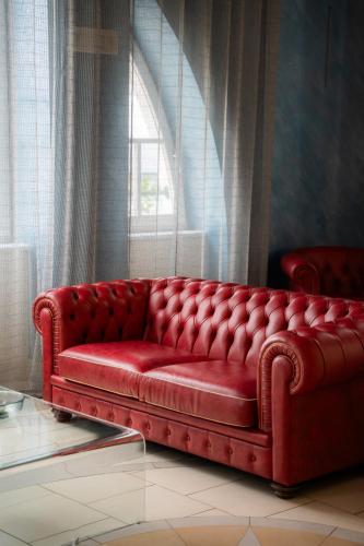 a red couch in a room with a window at HOTEL DEL GOLFO in Finale Ligure