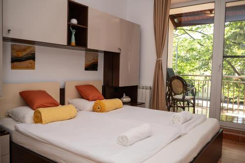 a bedroom with a large white bed with orange and yellow pillows at Mamamia Apartman in Gyula