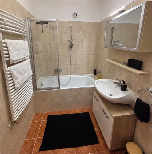 a bathroom with a tub and a sink and a shower at Mamamia Apartman in Gyula
