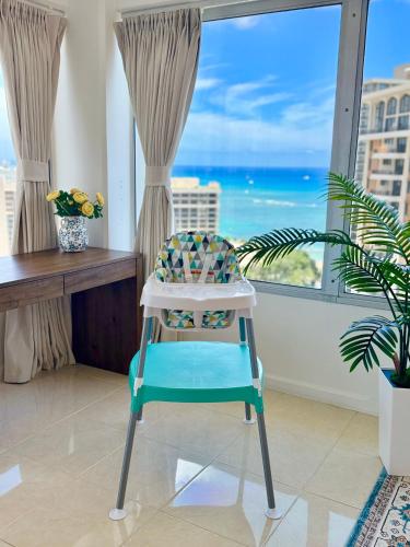 a blue and white chair in a room with a window at Panoramic Oceanview Resort - Full Kitchen in Each Unit, 2 Swimming Pools, Onsite Restaurants, Fireworks Every Friday in Honolulu