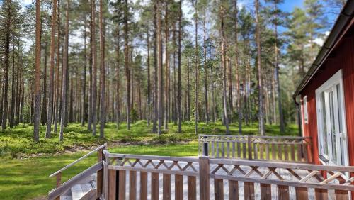 a porch of a red house in the woods at Lövnäs Sommarhus in Sörsjön