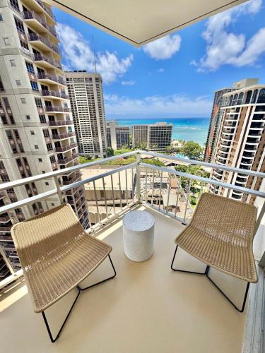 a balcony with two chairs and a view of the ocean at Panoramic Oceanview Resort - Full Kitchen in Each Unit, 2 Swimming Pools, Onsite Restaurants, Fireworks Every Friday in Honolulu