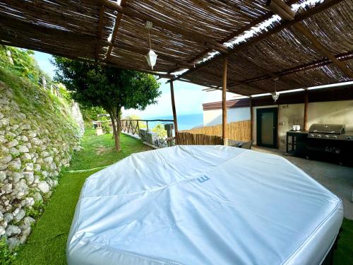 a large white table under a wooden roof at Relais Amalfi Coast in Conca dei Marini