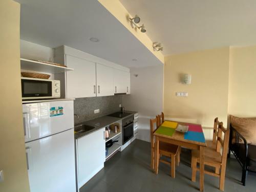 a kitchen with a table and a refrigerator and a dining room at Bonito apartamento en Avinyó con impresionantes vistas in Avinyó