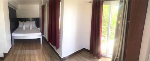 a room with a bedroom with a bed and a window at NVH4 Nanay Vacation Home Coron Palawan in Coron