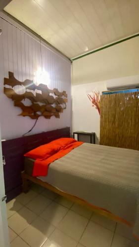 a bedroom with a bed with an orange blanket at Air conditioned home with full kitchen, TV and parking in Puerto Viejo