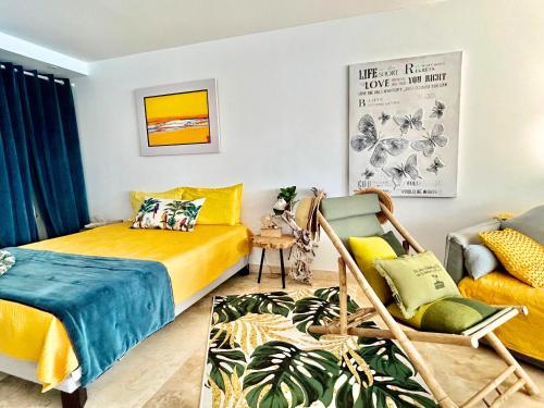 1 dormitorio con cama amarilla y sofá en Studio So Lovely, stunning sea view, en Cul de Sac