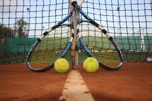two tennis rackets and two tennis balls on a court at Life Sport Hotel in Mentana