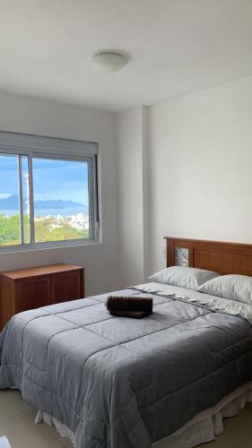 a bedroom with a large bed with a large window at Ap Royal Mirage in Florianópolis
