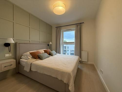 a bedroom with a bed with a large window at Cosmo Apartments Baltic Sea in Gdańsk