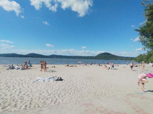 a group of people on a beach with the water at Chata Veverka in Doksy
