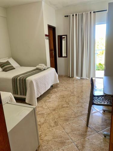 a hotel room with two beds and a chair at Pousada do Guinda DIAMANTINA -MG in Diamantina