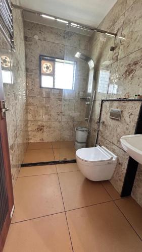 a bathroom with a toilet and a sink at Tranquil Touch in Chikmagalūr