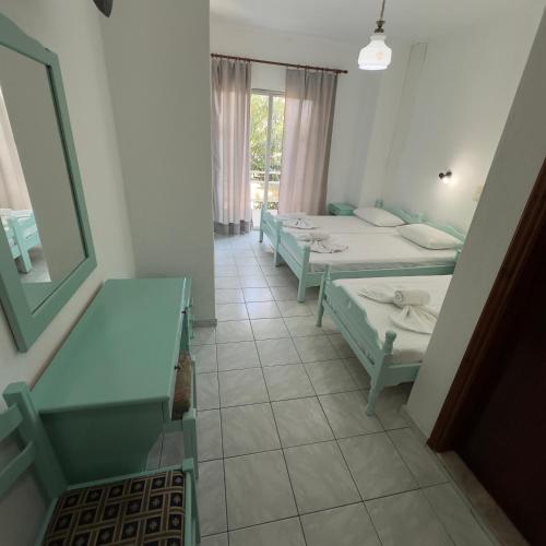 a room with four beds and a window at Villa Eleni - Thassos Town in Limenas