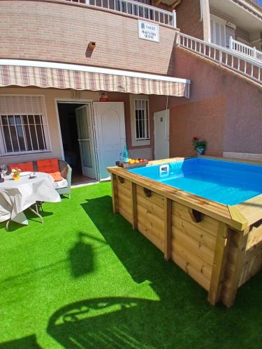 Una gran piscina en un césped frente a una casa. en Bungalow sea view, en Torrevieja